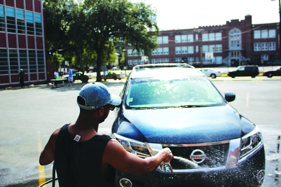 Alpha Phi Alpha President Matthew Draughter, international business senior, washes a car. Alpha Phi Alpha held a car wash on Saturday, Nov. 5, 2016 to kick off Alpha Week. Photo credit: Alliciyia George