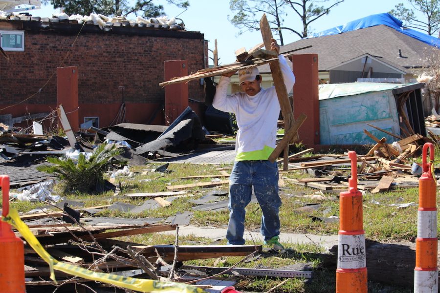 A worker with Mr. Fix It helps to pile up the debris left after the storm. Shortly after the storm, volunteers from all over came to aid those affected by the storm.