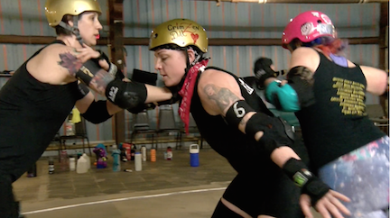 CrimZen Doll, a Big Easy Roller Girl, practices blocking on the rink. 