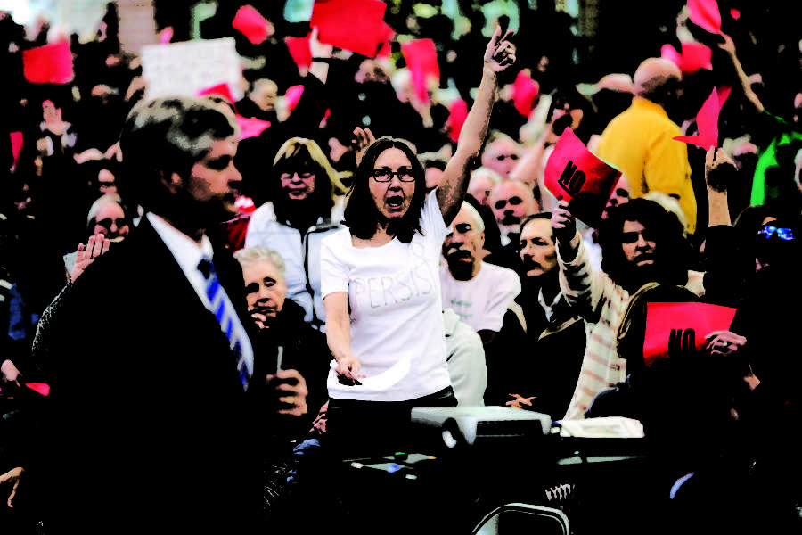 Rep. Jeff Fortenberry, R-Neb., gets a reaction from the crowd, including Judy Martindale of Lincoln, center, after he said he is against funding Planned Parenthood, during a town hall in Lincoln, Neb., Monday, March 13, 2017. (AP Photo/Nati Harnik)