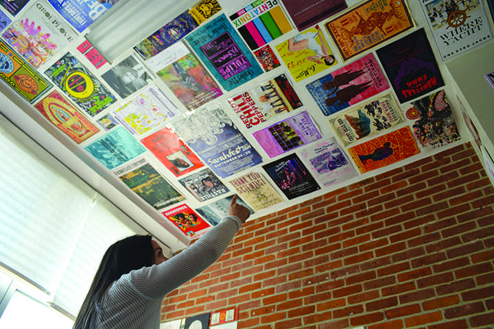 Emmaline Bouchillon points at her ceiling, which is adorned with posters both her and her roommate, Avery Cerniglia,  picked out. Personal style is an easy way to show off your personality in your living space and make it feel more like home. Photo credit: Davis Walden