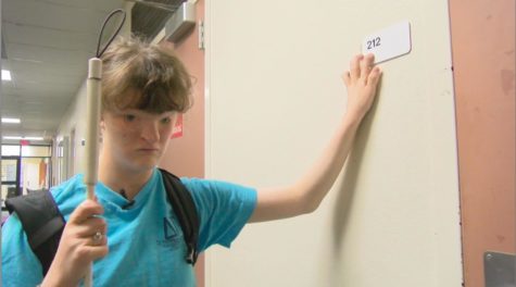 Sophie Trist, English writing freshman, uses the new Braille signs placed around to read.  After various complaints to campus disability services and talking with some peers involved in SGA, they were able to get Physical Plant to make new classroom signs that included Braille.