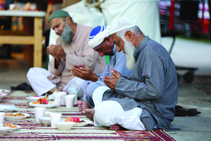 Iqbal Gagan, right, prays with members of his mosque before breaking Ramadan fast at the Islamic Center of Orlando, Fla., on June 30, 2016. The Center saw a dramatic drop in attendance at these meals following the Pulse shootings, but have seen people come back, especially after hiring more security guards to stand watch. (Joshua Lim/Orlando Sentinel/TNS)