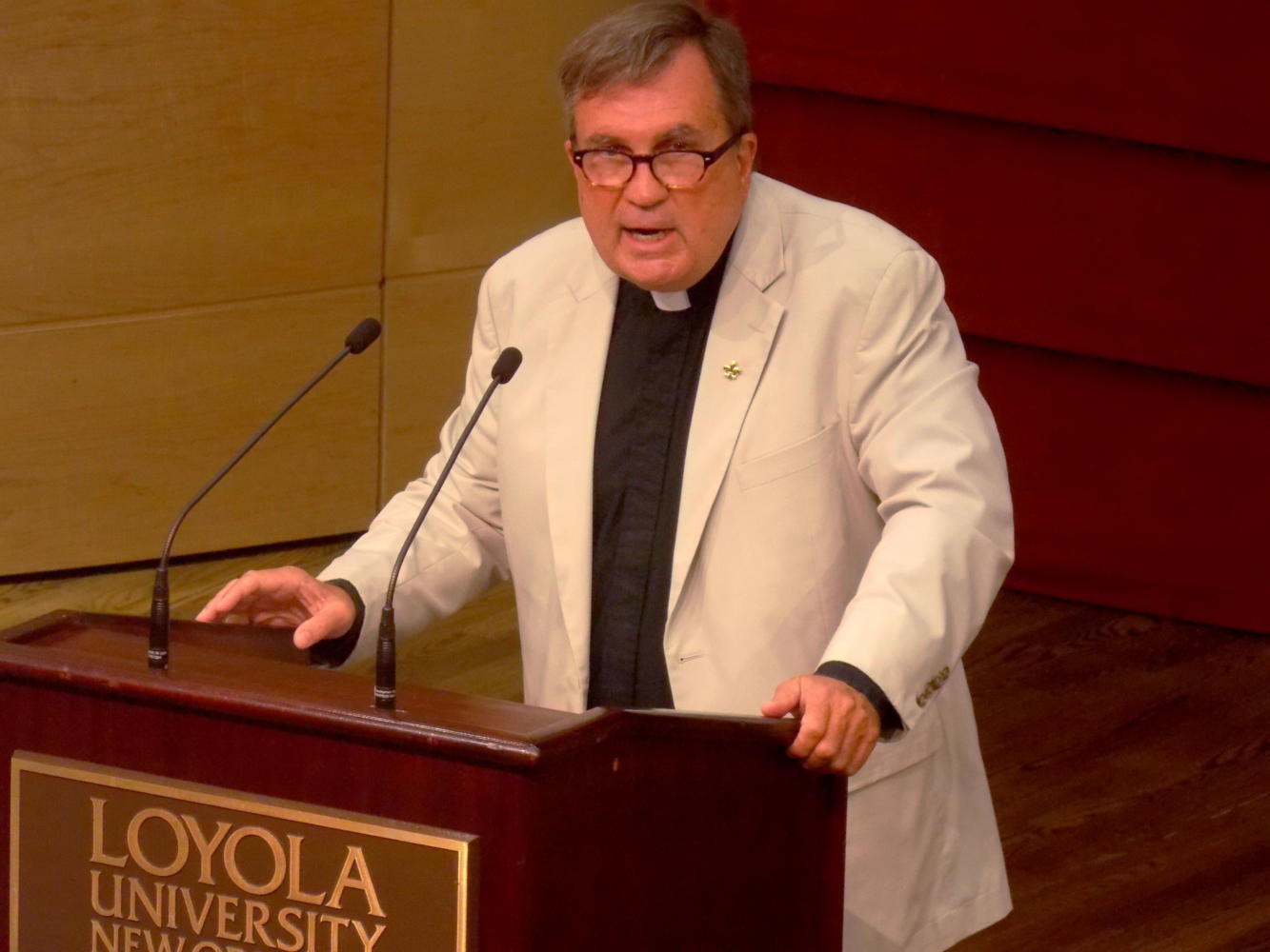 The Rev. Kevin Wildes, S.J., university president, addresses faculty at a convocation. Photo credit: The Maroon