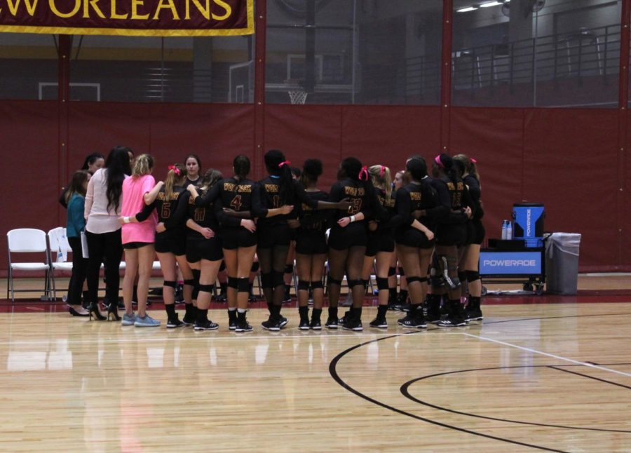 The Loyola volleyball team gathers in a group huddle during the game. The 2017 Loyola volleyball team plans to compete against the 2002 volleyball team on January 19 at 7pm at the Den. Photo credit: Cristian Orellana