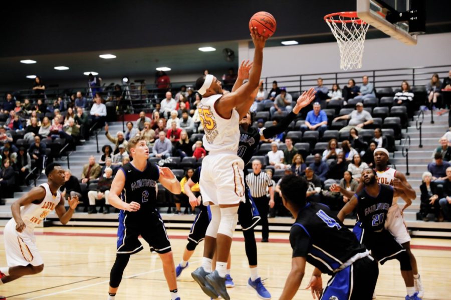 Senior, #55 Benjamin Fields, rebounds and shoots the ball. Fields led the team with a total of 14 points at the Faulkner University game in the den Jan. 20, 2018. Photo credit: Julia Santos