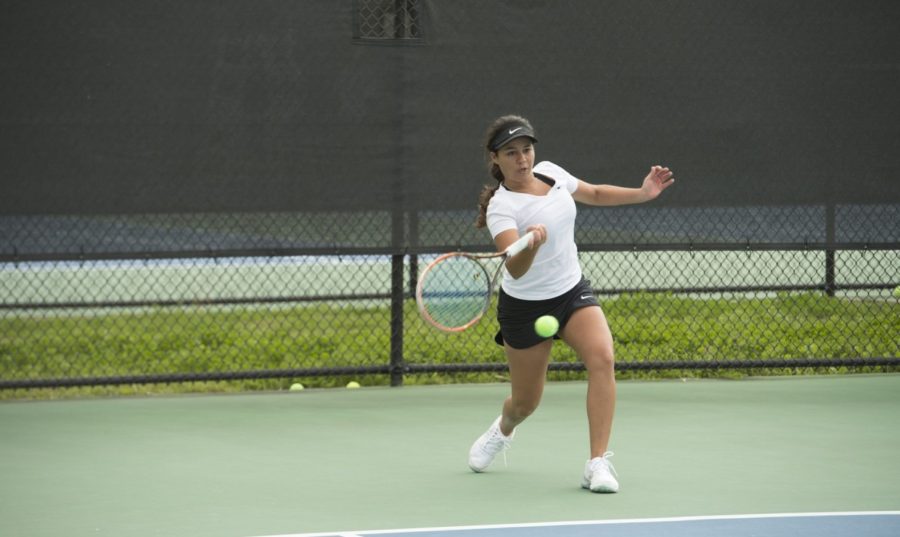 Koral Martinez, biology junior, hits a serve on a tennis court. This season, the mens tennis team has a 6-4 record and the womens team has a 5-6 record. Photo credit: Loyola University Athletics