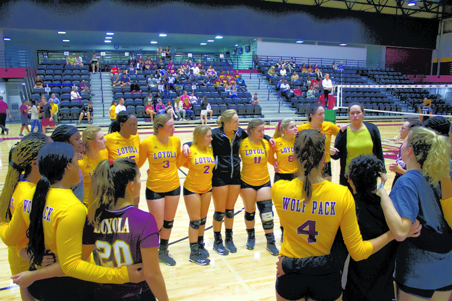 The Loyola volleyball team gathers in a group huddle during the game. The volleyball team has achieved record-breaking success under Jesse Zabal’s first year as head coach. Photo credit: The Maroon