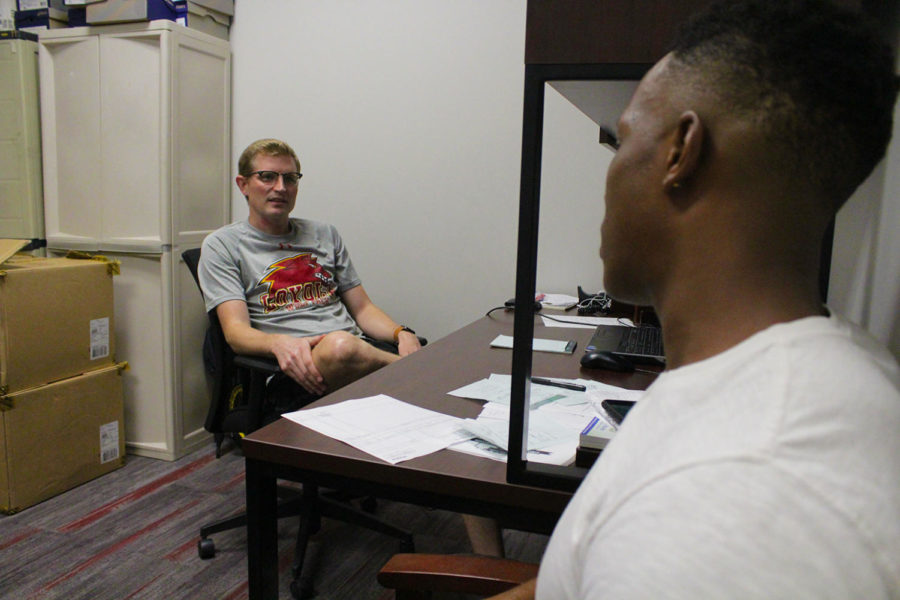 Track and Field and Cross Country Coach Kevin Licht meets with a new recruit transferring from Dillard University Stephano Flowers. Licht is entering his first year at Loyola. Photo credit: RoshaE Gibson