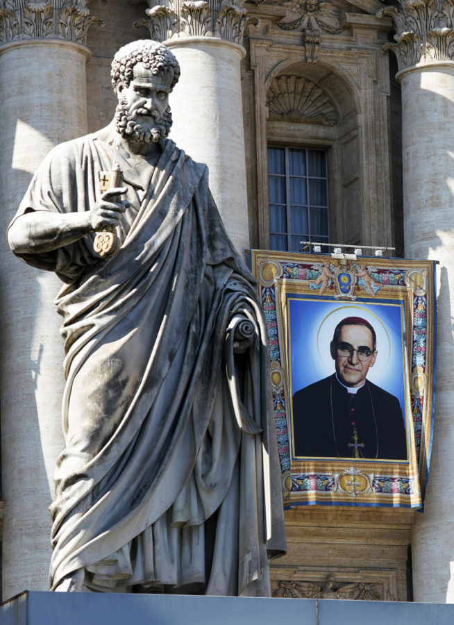 The tapestry of Roman Catholic Archbishop Oscar Romero hangs from a balcony of the facade of St. Peters Basilica at the Vatican, Saturday, Oct. 13, 2018. Pope Francis will canonize two of the most important and contested figures of the 20th-century Catholic Church, declaring Pope Paul VI and the martyred Salvadoran Archbishop Oscar Romero as models of saintliness for the faithful today. (AP Photo/Andrew Medichini)
