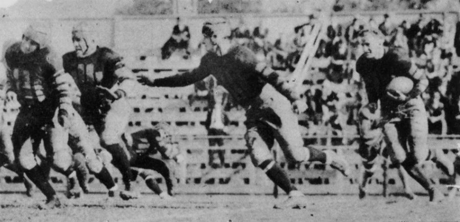 Here is an example of the airtight interference given Buck Moore on his long runs. Much praise has been showered on Buck for the manner in which he has broken loose in every game for sensational dashes, and just as much is due his interferers. The photo, snapped during the Lincoln game, shows Charlie Jaubert at the extreme left, Don Maitland next behind him, and Red Gremillion in front of Moore.