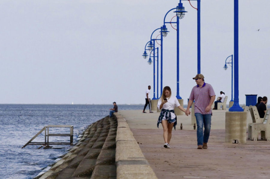 A couple strolls along the sidewalk by Lake Pontchartrain. The site is frequented by residents for its natural beauty. Photo credit: Andres Fuentes