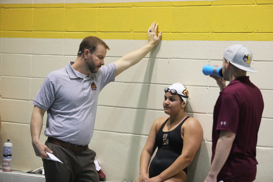 Swim Head Coach Thomas Natal coaches international buisness sophomore Andrea van den Berg at a Loyola swim meet.  Both swim teams have found national success in the past few years.