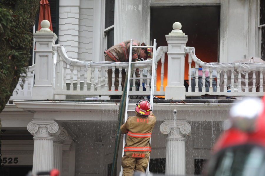 Two fire fighters climb a ladder in order to fight the flames engulfing the Rex Mansion. The historic mansion caught fire early Wednesday morning. Photo credit: Andres Fuentes