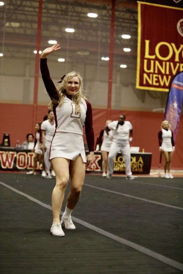 Biology senior Kristen Williams waves to the crowd during the cheer teams conference routine.