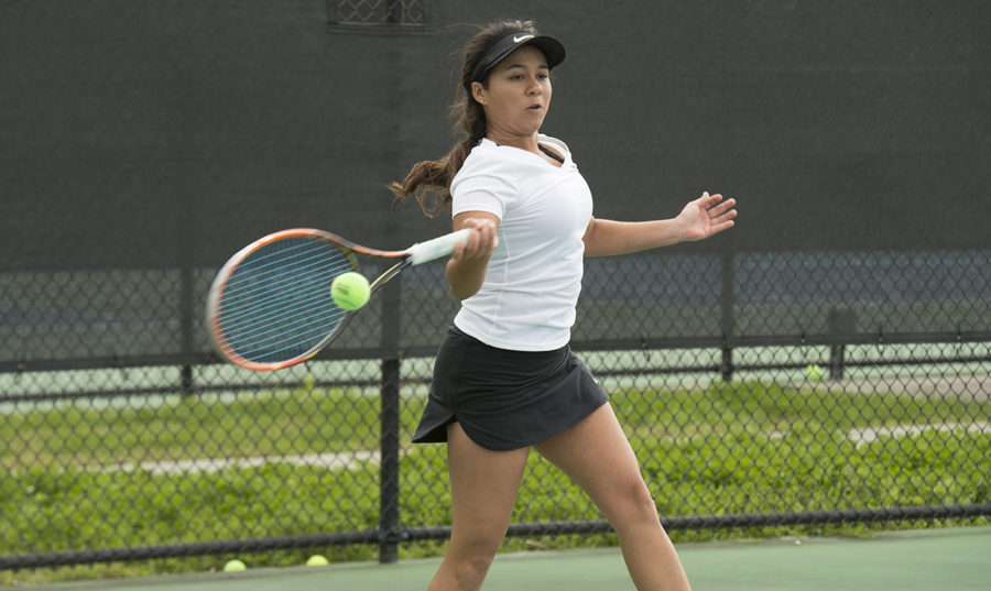 Biology senior Koral Martinez hits a tennis ball at City Park. Photo credit: Loyola New Orleans Athletics