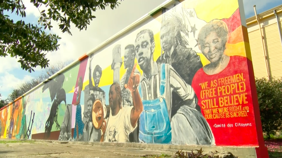 A mural commemorating U.S. civil rights struggles sits on display near the intersection of Royal Street and Homer Plessy Way. The mural, painted by artist Ayo Scott, was commissioned by the New Orleans Center for Creative Arts and presented to the public last year. Photo credit: India Yarborough