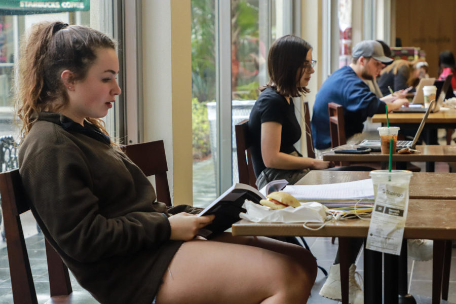 A Loyola student studies at Starbucks in the Danna Center with her coffee that she ordered using Tapingo. The express service allows students to order food and beverages ahead of time and pick them up at their convenience. Photo credit: Rob Noelke