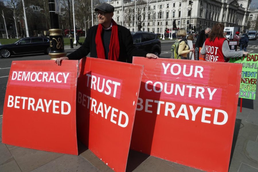 A pro-Brexit protester holds onto placards as he demonstrates near the House of Parliament in London, Tuesday, March 26, 2019. British Prime Minister Theresa Mays government says Parliaments decision to take control of the stalled process of leaving the European Union underscores the need for lawmakers to approve her twice-defeated deal. (AP Photo/Alastair Grant)