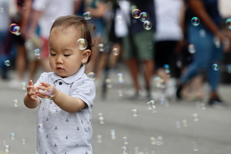 A child plays with bubbles on Decatur Street. Families travel from across the country to get a taste of what French Quarter Fest has to offer.