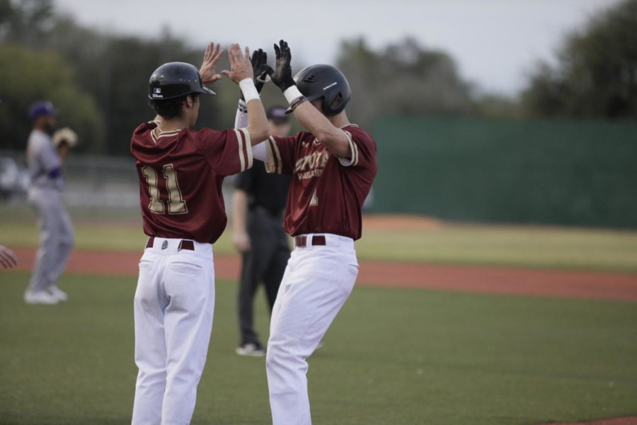 Biophysics+freshman+Derek+Oliveras+%2811%29+celebrates+with+biological+sciences+sophomore+Luke+Lacoste+%281%29+at+first+base.+Loyola+won+both+games+versus+Tougaloo+College.+Photo+credit%3A+Andres+Fuentes