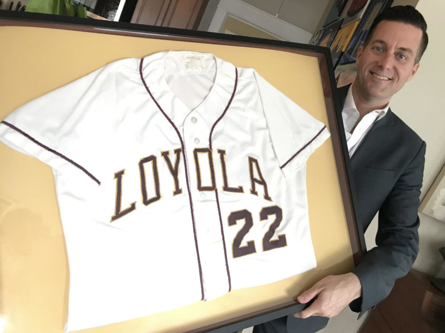 Fletcher Mackel poses with his framed Loyola jersey. He decided to frame his jersey after losing college memories during Hurricane Katrina. Courtesy of Fletcher Mackel.