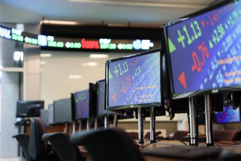 Stock prices scroll across the computer monitors in the trading room on Aug. 21, 2019. Loyola students made money on their investments last week despite market volatility. Photo credit: Michael Bauer