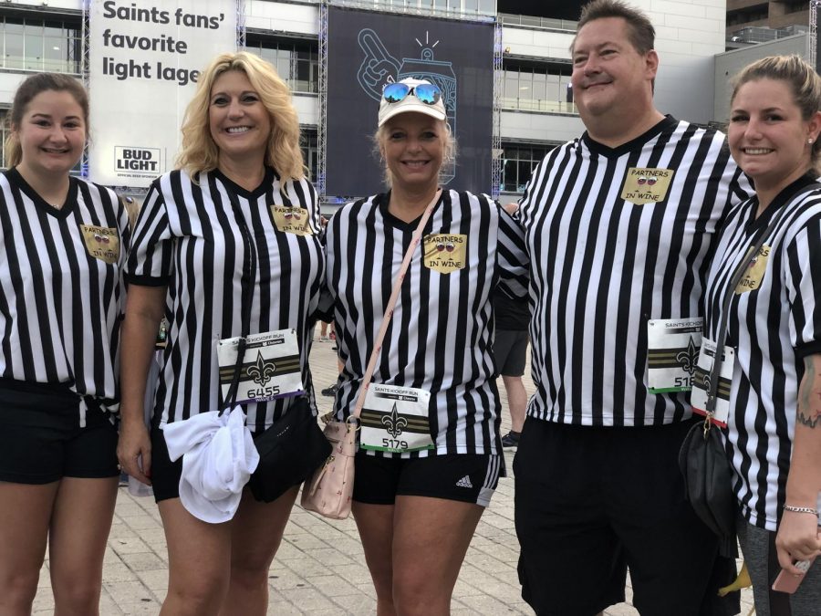 Jennifer Dutchover (center left) and Kim Koplin (center) pose with their family, dressed as referees at the Saints Kickoff Run on Sept. 7. Dutchover and Koplin traveled from Biloxi, Mississippi and Chicago, Illinois respectively, for the run. Sam Lucio/The Maroon Photo credit: Sam Lucio