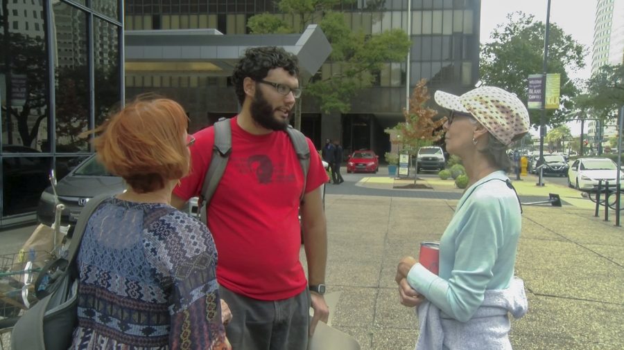 Daniel Werst speaks to other protesters in front of the ICE office in New Orleans Oct. 12. Werst said he supports an open border policy. Photo credit: Cody Downey