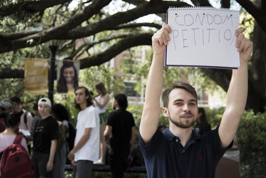 Gabriel Lesser holding up a sign in support of a petition to get condoms on campus on Oct. 8. Lesser sponsored the Student Government Association resolution for sex education. Michael Bauer/The Maroon.