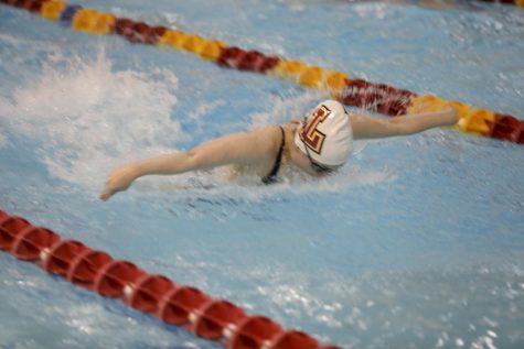 Loyola swimmer hits the pool in a meet. The swim team holds practices at six in the morning every day except for Sunday. Photo credit: Andres Fuentes
