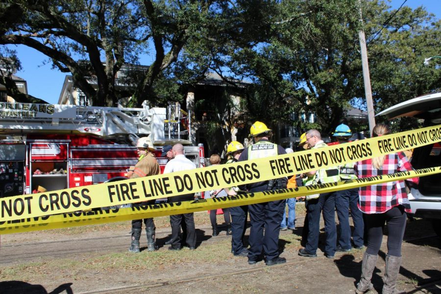 First responders stand behind a fire line on the scene of a four-alarm fire