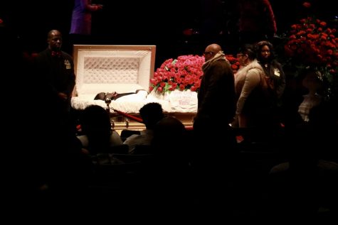 Mourners stand next to 5th Ward Weebie's casket at his funeral.