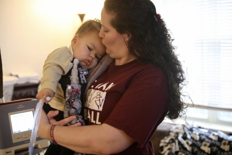 Andrea James and her son, Axel Dennis, embrace in their living room. Axel suffers from SMA and has twice been denied a life-saving drug from the Louisiana Department of Health. Photo credit: Andres Fuentes