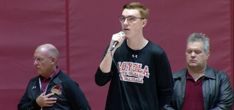 Men's basketball manager Sam Ater sings the national anthem at a home game. Ater is a music and elective studies major. Courtesy of Loyolawolfpack.com.