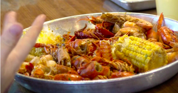 A platter of crawfish with corn