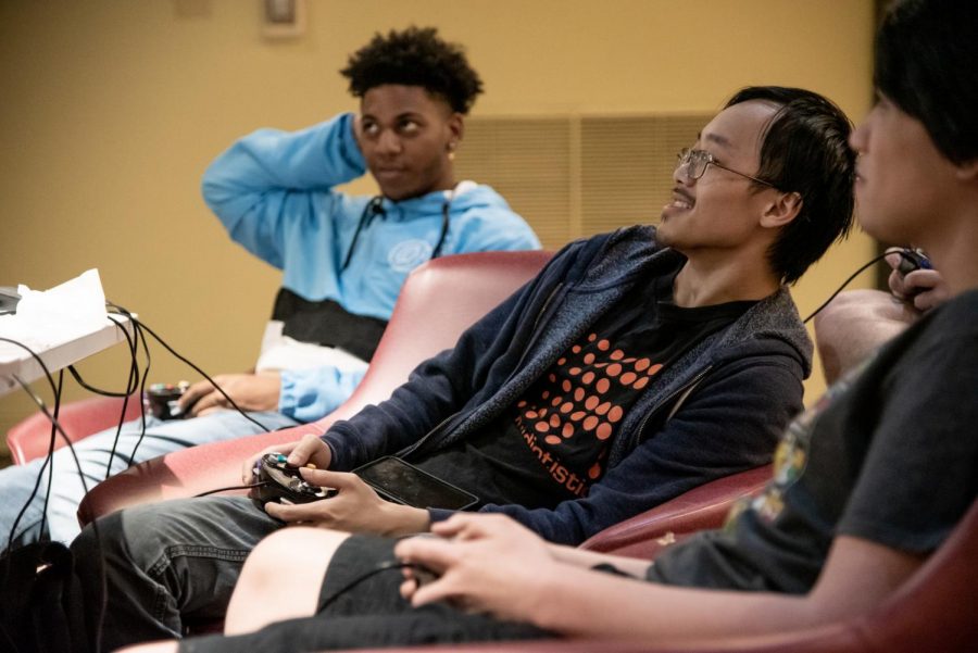 Gaming club President Quinton Liang (center)  plays Super Smash Bros in Satchmos Lounge. E sports is a club sport at Loyola.  Mike Bauer \The Maroon