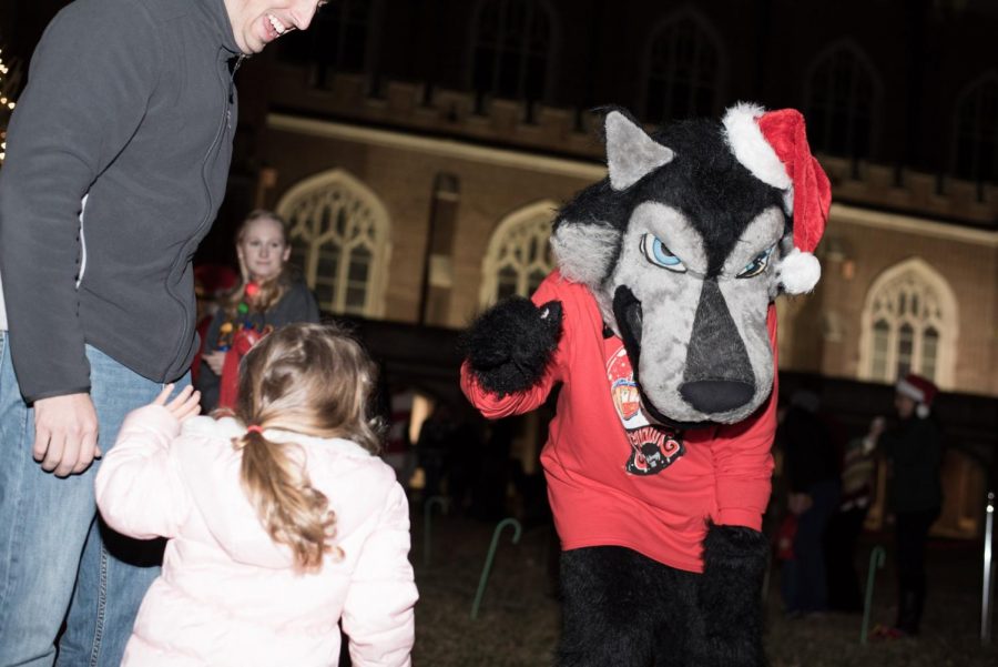 Loyolas mascot Havoc T. Wolf greets a child at Snow this December. Havoc has an instiric connection to Jesuit traditions. Mike Bauer/The Maroon