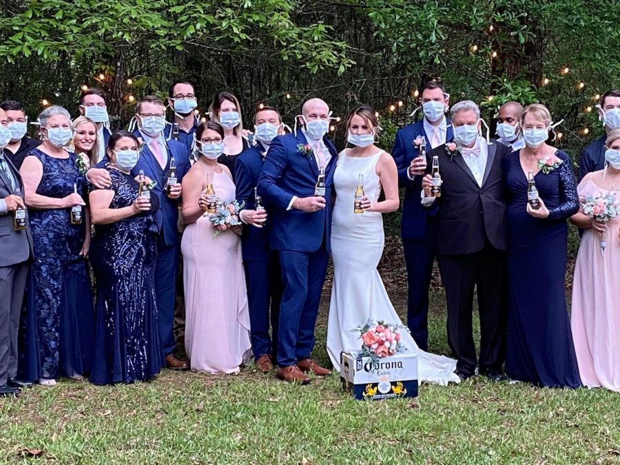 Only about 20 people showed up to Elvin and Jessica Ryans wedding after the ceremony had to be re-organized due to COVID-19. The couple had guests pose with surgical masks and Corona beers to make light of the situation. Courtesy of Jessica Ryan