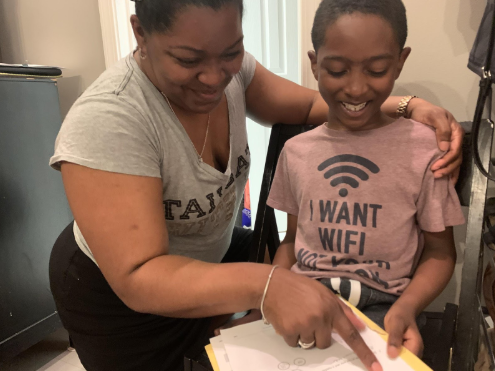 Natalie Reaux helping her son Maxx Reaux with some math homework before his afternoon snack.