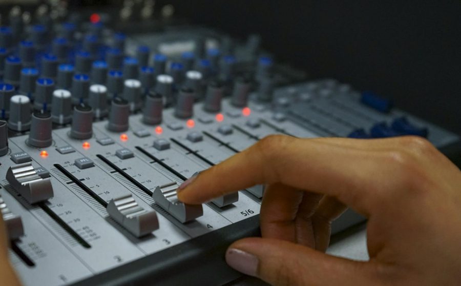 A student adjusts the volume dial on a mixer in one of Loyola's recording studios in the College of Music and Media. Billboard Magazine named the college one of the Top Music Business Schools for 2020. Photo credit: Cristian Orellana