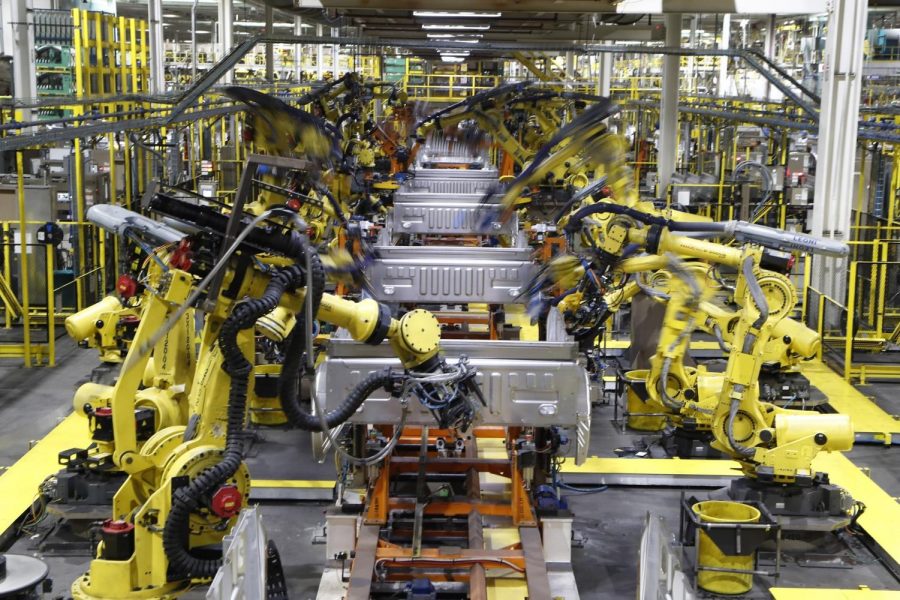 In this Sept. 27, 2018, file photo robots weld the bed of a 2018 Ford F-150 truck on the assembly line at the Ford Rouge assembly plant in Dearborn, Mich.  U.S. businesses are edging their way toward figuring out how to bring their employees back to work amid the coronavirus pandemic, a transition that some say will result in increased automation. (AP Photo/Carlos Osorio, File)