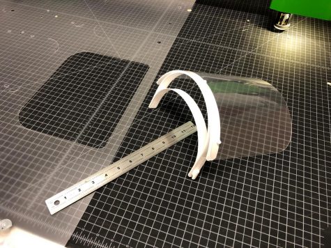 A 3D printed face shield sits on a desk.