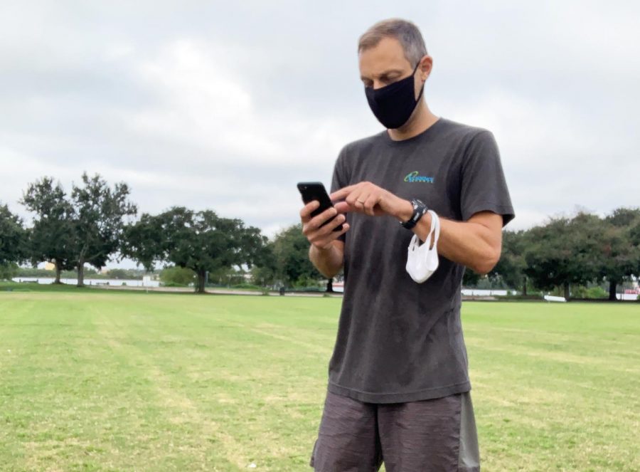 Wolf Pack head cross country coach Geoff Masanet checks his phone at practice. Loyola coaches have had to recruit entirely virtually this year. Photo credit: Jae Schifano