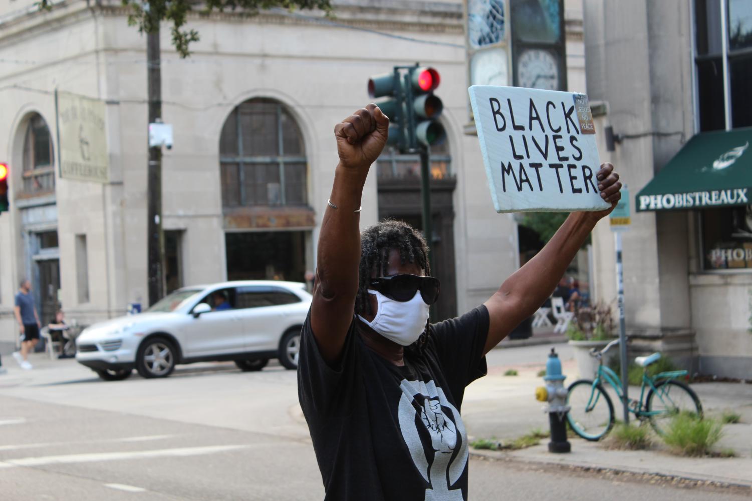 A Protestor on South Carrolton holds up a Black lives matter sign.