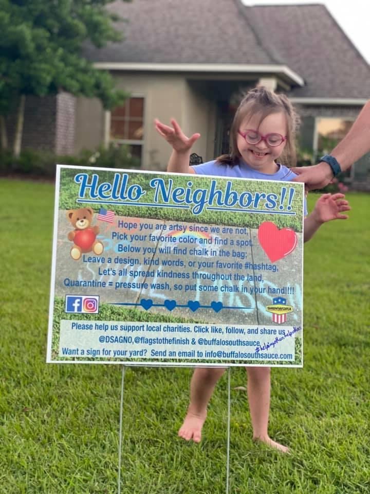 A little girl stands behind a sign with a poem on it asking people to leave a message in their neighborhood.  Ryan Mast created these signs and took them all around southeast Louisiana to stay connected with the community.  Courtesy of Ryan Mast. 
