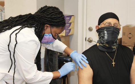 Fourth year pharmacy student Tiffani Collins innoculates Wilfred Griffin, Jr. with his second dose of the COVID-19 vaccine at Crescent City Pharmacy Feb. 18, 2020. COVID-19 Pfizer booster shots are available at Tulane’s Lavin-Bernick Center. 