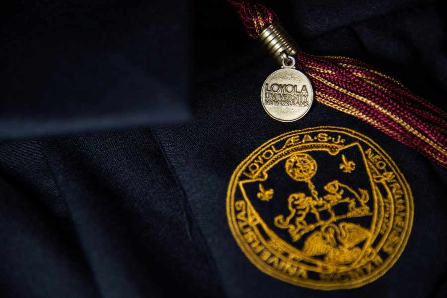 A graduation tassel lays across a gown decked out in Loyolas emblem. Loyola has announced its official graduation plans for the class of 2021.