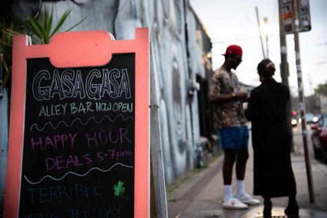 People stand near a sign advertising the reopening of Gasa Gasa.