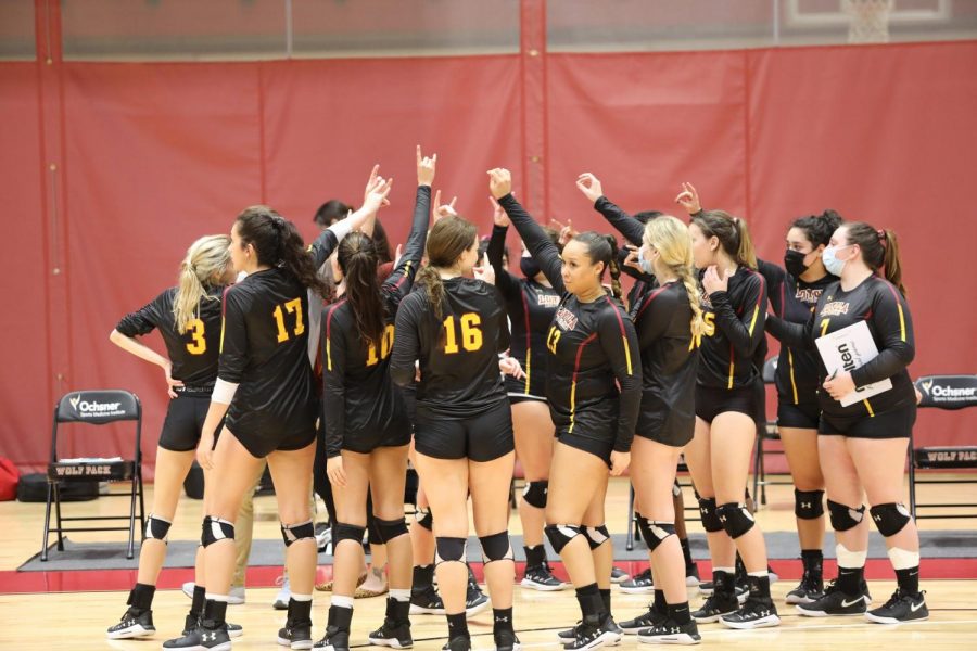 The Loyola volleyball team makes the Wolf Pack hand symbol while breaking a huddle during a victory against Brewton-Parker on March 13. Photo credit: Hannah Renton